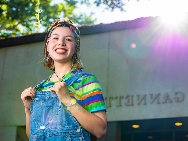 A Fullbright Scholar smiling, standing outside of the Gannet Center.